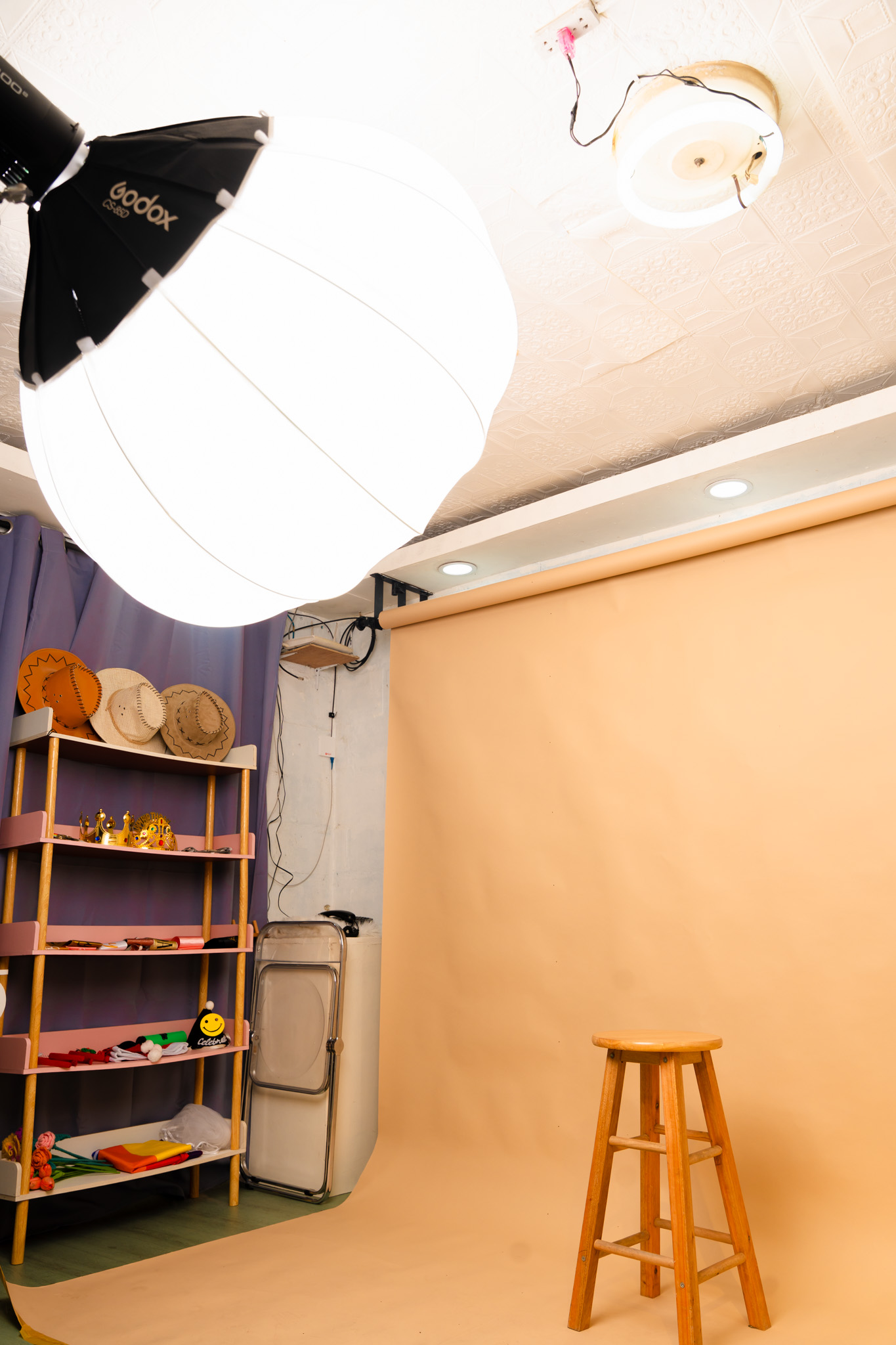 Inside the EZ Clicks Studio — softbox lighting, props shelf, and the pongee backdrop setup